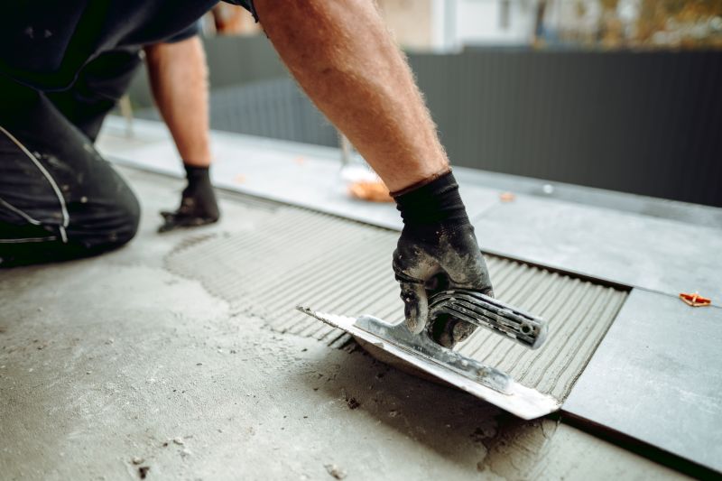 Floor installer laying adhesive with a trowel
